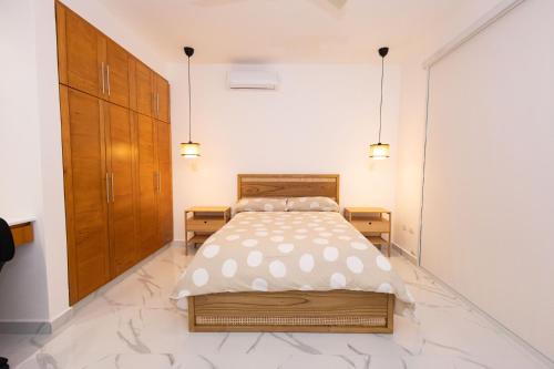 a bedroom with a bed and two wooden cabinets at Ka' Romana Residences in El Soco
