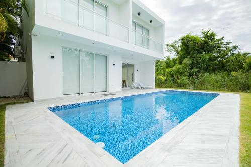 a white house with a swimming pool in front of it at Ka' Romana Residences in El Soco