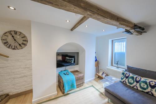 a living room with a clock on the wall and a couch at St. John’s hill - with parking in Shrewsbury