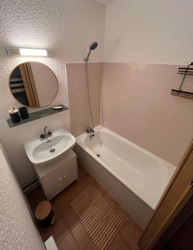 une salle de bain avec une baignoire, un lavabo et un miroir dans l'établissement Domaine de la Coudouliere - Studio, à Six-Fours-les-Plages