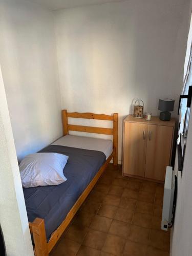 une petite chambre avec un lit et une table de chevet dans l'établissement Domaine de la Coudouliere - Studio, à Six-Fours-les-Plages