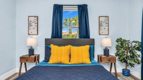 a bedroom with a blue bed and a window at Peanut Island Paradise I 4 Mins to Island Shuttle! in West Palm Beach