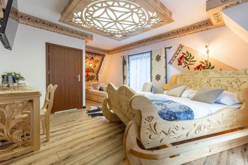 a bedroom with a large bed and a chandelier at Kilimy in Poronin