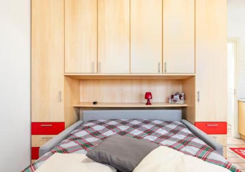 a bed in a room with white cabinets at La finestra dei Batù by Alterego in Villanova dʼAsti