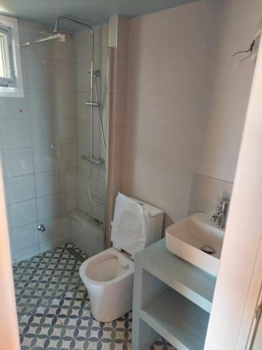a bathroom with a toilet and a sink at The Yellow Houses in Ayios Nikolaos Sithonia