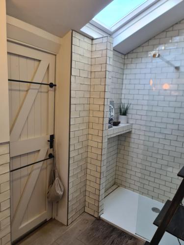 a bathroom with a shower with a glass door at Luxury beachfront property Cockles-Sea View-private parking for 2 cars-sleeps 10 in Exmouth