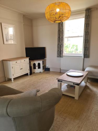 a living room with a couch and a coffee table at Luxury beachfront property Cockles-Sea View-private parking for 2 cars-sleeps 10 in Exmouth