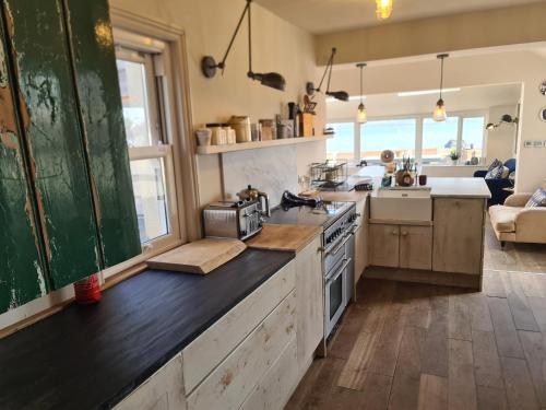 a kitchen with a counter with a stove top oven at Luxury beachfront property Cockles-Sea View-private parking for 2 cars-sleeps 10 in Exmouth