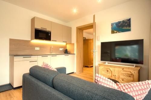 a living room with a couch and a flat screen tv at Apartment MarLen in Eben am Achensee