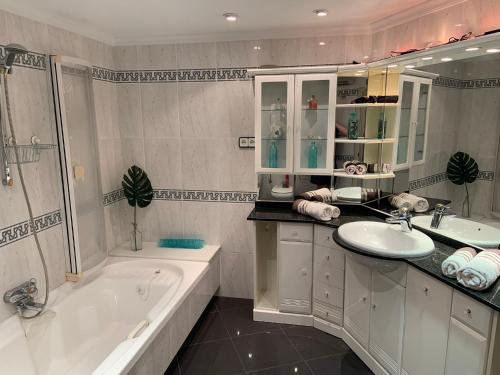 een badkamer met een bad en een wastafel en een ligbad bij ATICO AMBERES SEAVIEW PENTHOUSE - Torrox Costa in Castillo Bajo