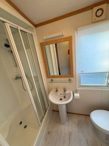 a bathroom with a sink and a shower and a toilet at Marsh Farm Holiday Park in Great Yarmouth