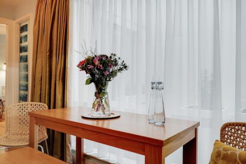 a table with a vase of flowers on it at Residences at The Gyle - London in London