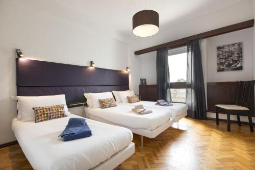 a hotel room with two beds and a large window at LV Premier Apartments Clerigos-RE2 in Porto