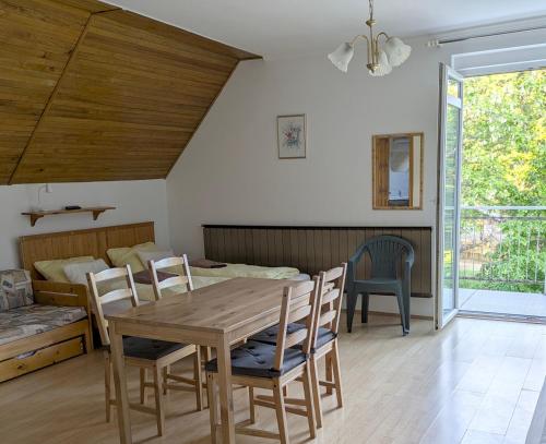 a dining room with a wooden table and chairs at Lívia Apartman in Balatonfüred