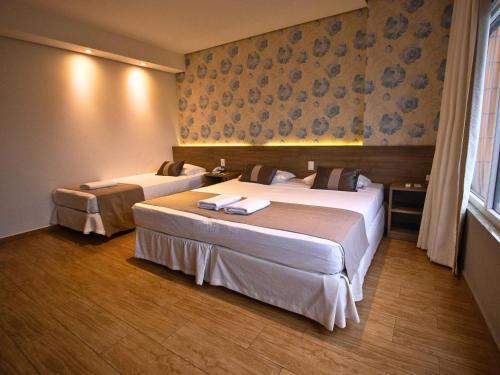 a hotel room with two beds in a room at Continental Inn in Foz do Iguaçu