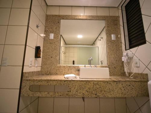 a bathroom with a sink and a mirror at Continental Inn in Foz do Iguaçu