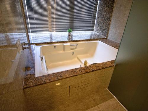 a large bath tub in a bathroom with a window at Continental Inn in Foz do Iguaçu