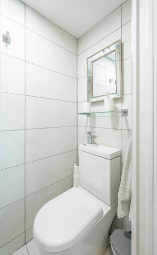 a white bathroom with a toilet and a mirror at St. John’s hill - with parking in Shrewsbury