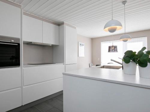 Una cocina con gabinetes blancos y una encimera blanca. en 8 person holiday home on a holiday park in Løkken, en Løkken