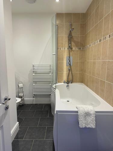 a bathroom with a bath tub and a shower at Tidemill House Apartment in Falmouth