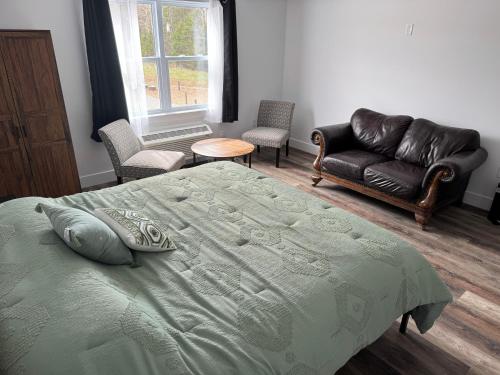 a bedroom with a bed and a leather couch at The Red Rest Motel by The Red Farm in Sydney
