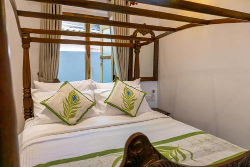 a bed with white pillows and a wooden canopy at New! Mangalam house, Private plunge pool near beach in Trincomalee