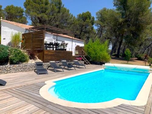 une piscine avec des chaises et une maison dans l'établissement Villa au coeur de la Provence, à Lambesc