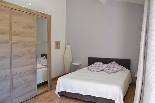 une chambre avec un lit blanc et un grand miroir dans l'établissement Villa au coeur de la Provence, à Lambesc