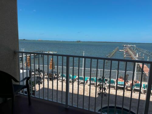 a balcony with a view of the water and a dock at Beso Del Sol Resort in Dunedin