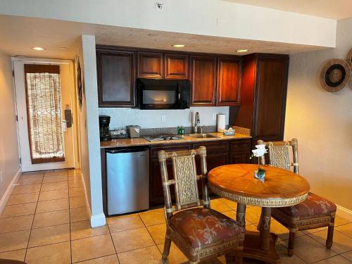 a kitchen with a table and a table and chairs at Beso Del Sol Resort in Dunedin