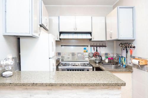 a kitchen with white cabinets and a counter top at Arkan Egyptian Museum Hotel in Cairo