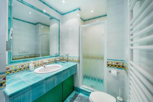 a bathroom with a sink and a toilet and a mirror at Villa nella curva della funicolare, Capri in Capri