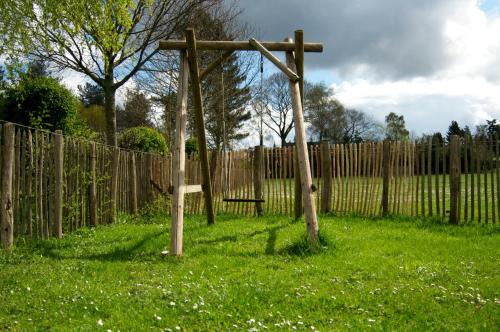 a wooden cross in a field next to a fence at B&B Maarle in Poppel