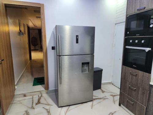a kitchen with a stainless steel refrigerator in a room at De- Fmoapartments in Lagos