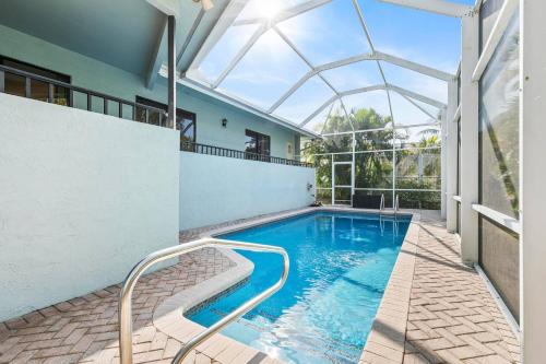 a swimming pool in a house with a glass roof at Walk to the Beach & Everywhere! Private Pool! in Henry Key