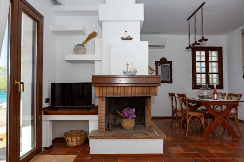 a living room with a fireplace and a table at Aeolia Seaside Residence in Kokkari in Kokkari