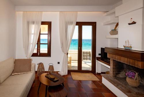 a living room with a fireplace and a view of the ocean at Aeolia Seaside Residence in Kokkari in Kokkari