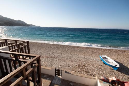 a blue boat sitting on a beach next to the ocean at Aeolia Seaside Residence in Kokkari in Kokkari