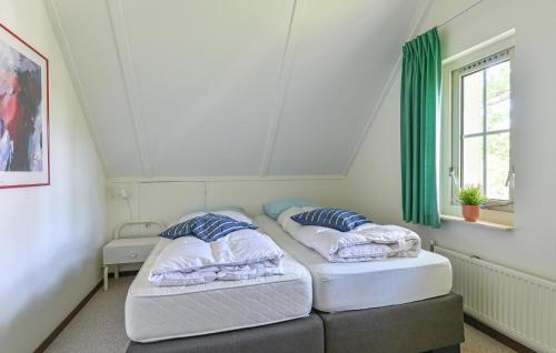 two beds in a small room with a window at Stunning Home In Exloo With Wifi in Exloo