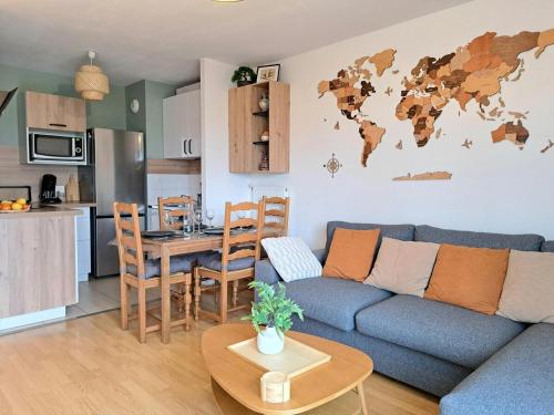 - un salon avec un canapé bleu et une carte du monde sur le mur dans l'établissement Parc Saint Andrew, à Saint-André