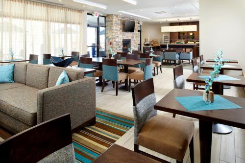 セント・クレアーズビルにあるHawthorn Extended Stay by Wyndham Saint Clairsvilleのテーブルと椅子とバーのあるレストラン