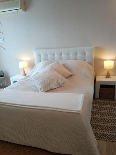 a bedroom with a white bed with two lamps at Les Volets Verts in Saint-Antonin-Noble-Val