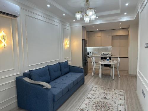 a living room with a blue couch and a table at Gala group in Akchiy