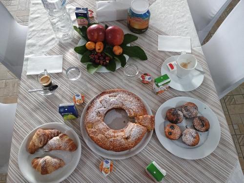 una mesa cubierta con platos de bollería y fruta en Oasi di san Benedetto, en Castellaneta