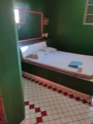 two beds in a room with a red and white floor at Motel ritz in Lavras