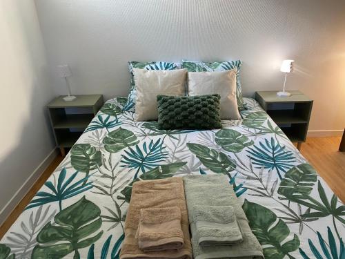 a bedroom with a bed with a green and white comforter at Maison proche centre village in Grignan