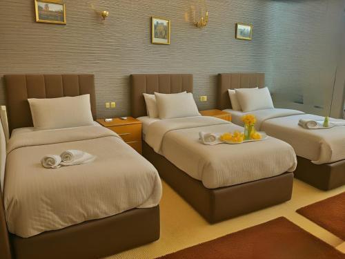 a room with three beds with towels on them at Arkan Egyptian Museum Hotel in Cairo