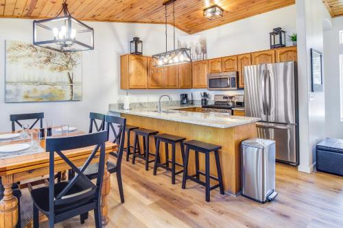 a kitchen with wooden cabinets and a bar with bar stools at Walk to City Park Family-Friendly Show Low Home in Show Low
