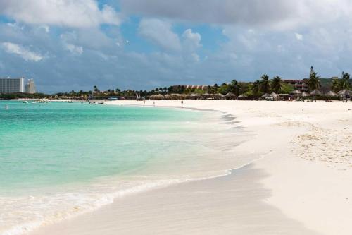 a beach with turquoise water and white sand at Beachfront- Eagle Beach- Top View 1BR condo - P514 in Palm-Eagle Beach