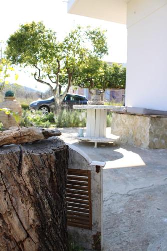 a table and a tree stump in a yard at Levanda Home in Taktikoúpolis